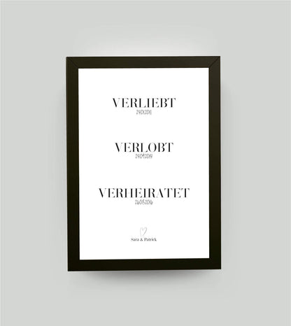 Personalisiertes Bild “verliebt - verlobt - verheiratet" - Datum, Bildfarbe: Weiß, Bildgröße: 13x18cm, Bilderrahmen: Bilderrahmen schwarz ohne Passepartout,Copyright: 321geschenke.de
